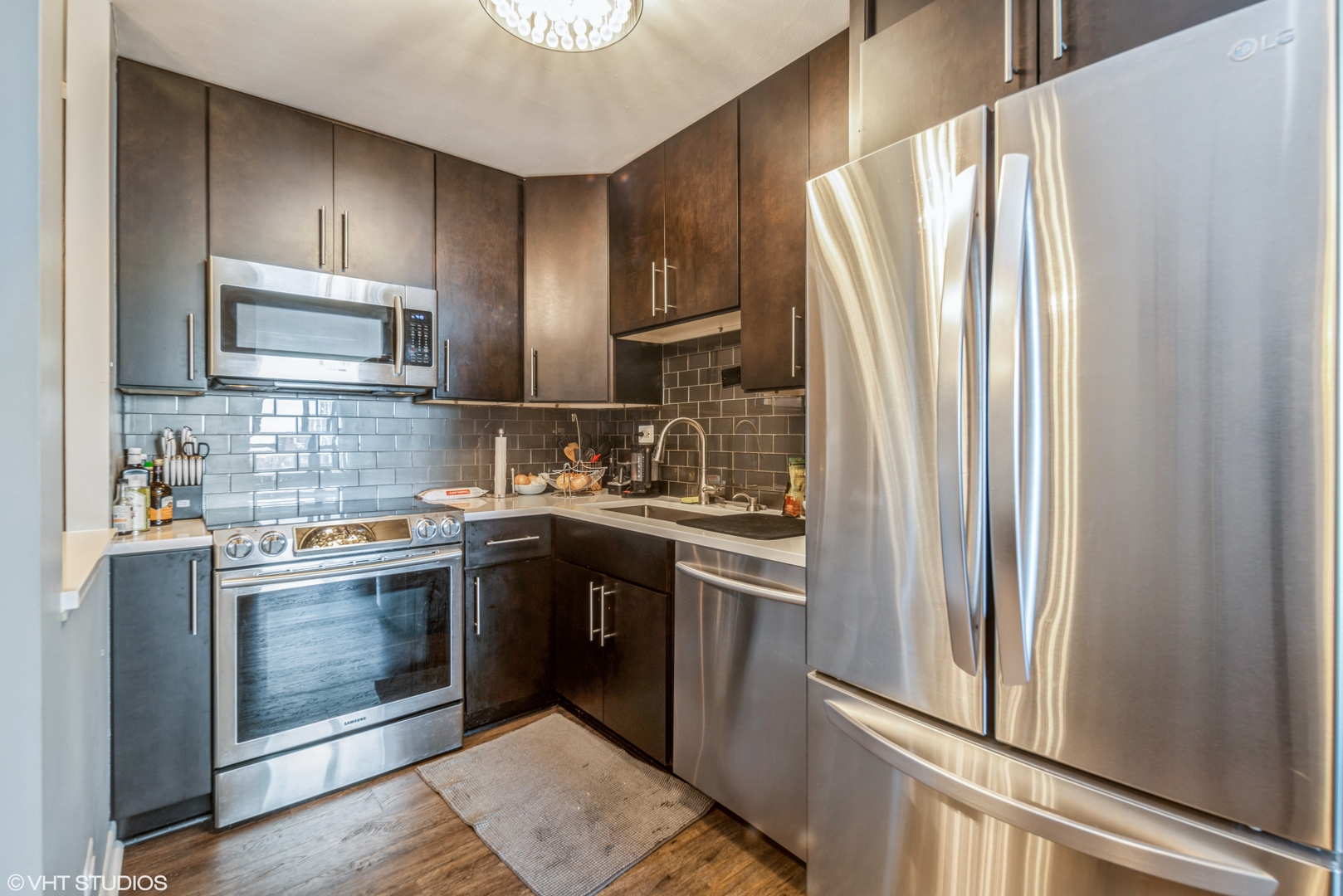 720 West Gordon Terrace, Unit 11F Chicago, IL 60613 - Photo 3 of 12 a kitchen with stainless steel appliances granite countertop a refrigerator stove and sink