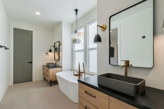 a spacious bathroom with a double vanity sink a mirror and a bathtub
