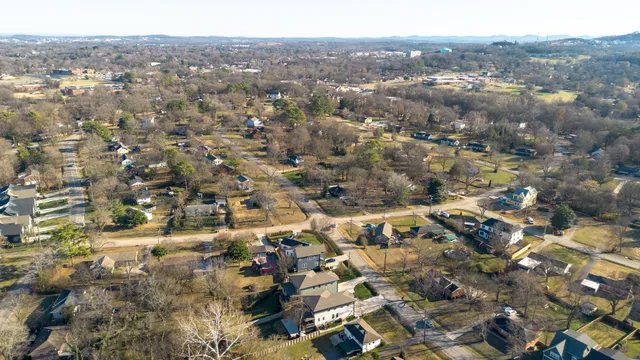 an aerial view of residential houses with outdoor space and trees