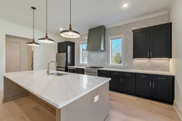 a kitchen with a sink a counter space and wooden floor
