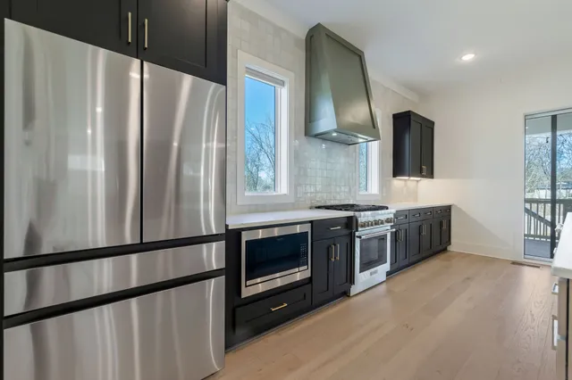 a kitchen with stainless steel appliances a refrigerator and a stove top oven