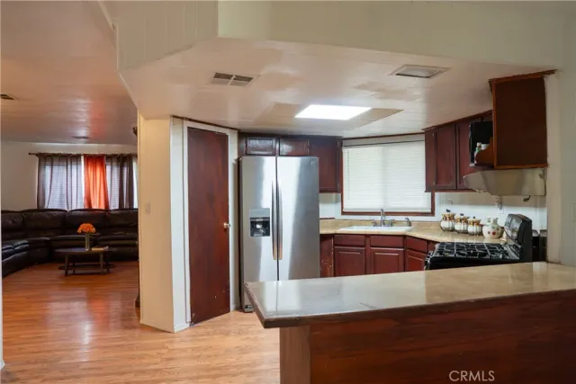 a kitchen with stainless steel appliances granite countertop a refrigerator a stove and a wooden floors