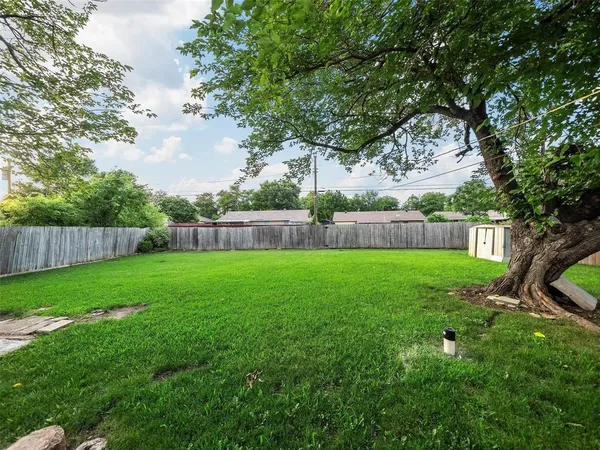 a view of yard with green space and wooden fence
