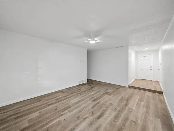 a view of an empty room and wooden floor