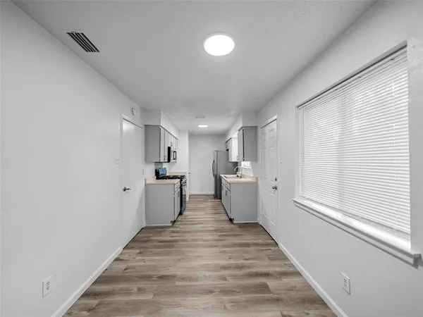 a view of a kitchen with wooden floor and electronic appliances