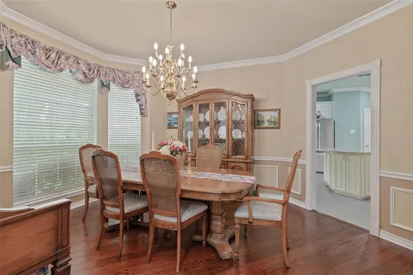 a view of a dining room with furniture a chandelier and wooden floor