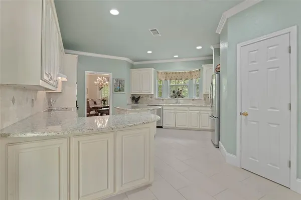 a kitchen with white cabinets and sink