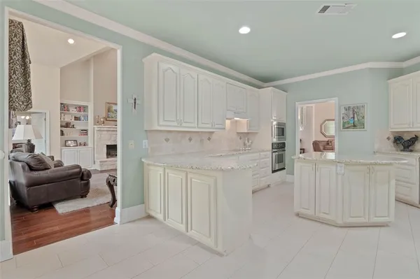 a kitchen with white cabinets and refrigerator