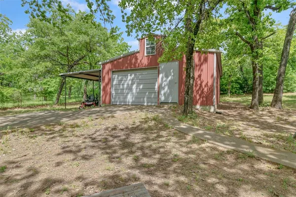 a view of a backyard with large trees and wooden fence
