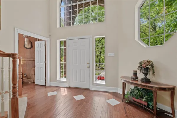 an empty room with windows and wooden floor