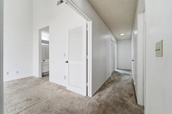 a view of a hallway with wooden shelves