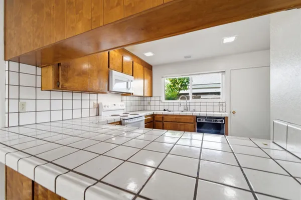 a kitchen with stainless steel appliances a sink window and cabinets
