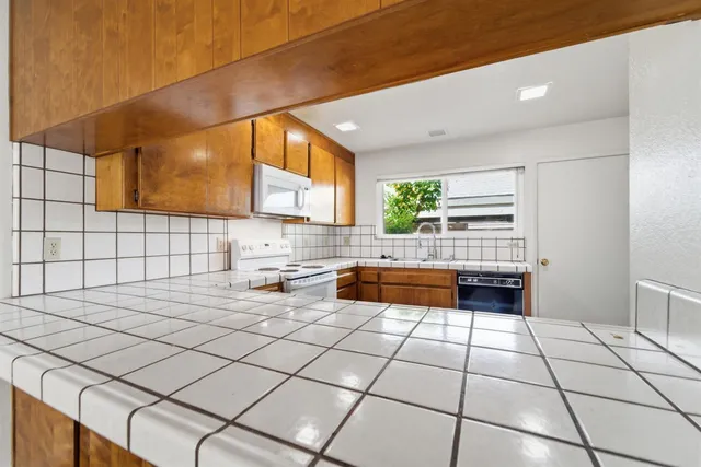 a kitchen with stainless steel appliances a sink window and cabinets