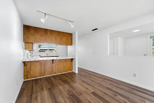a view of kitchen with stainless steel appliances wooden floor