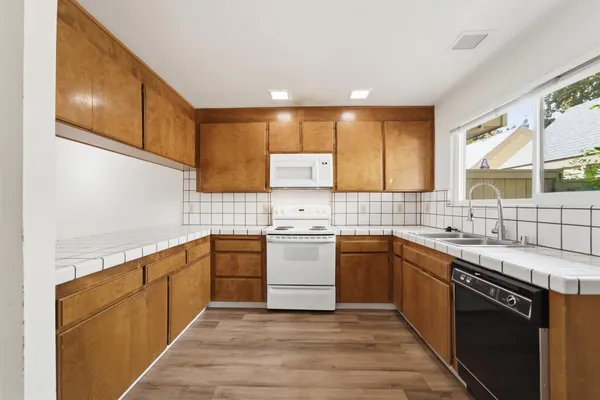 a kitchen with a sink cabinets stainless steel appliances and a window