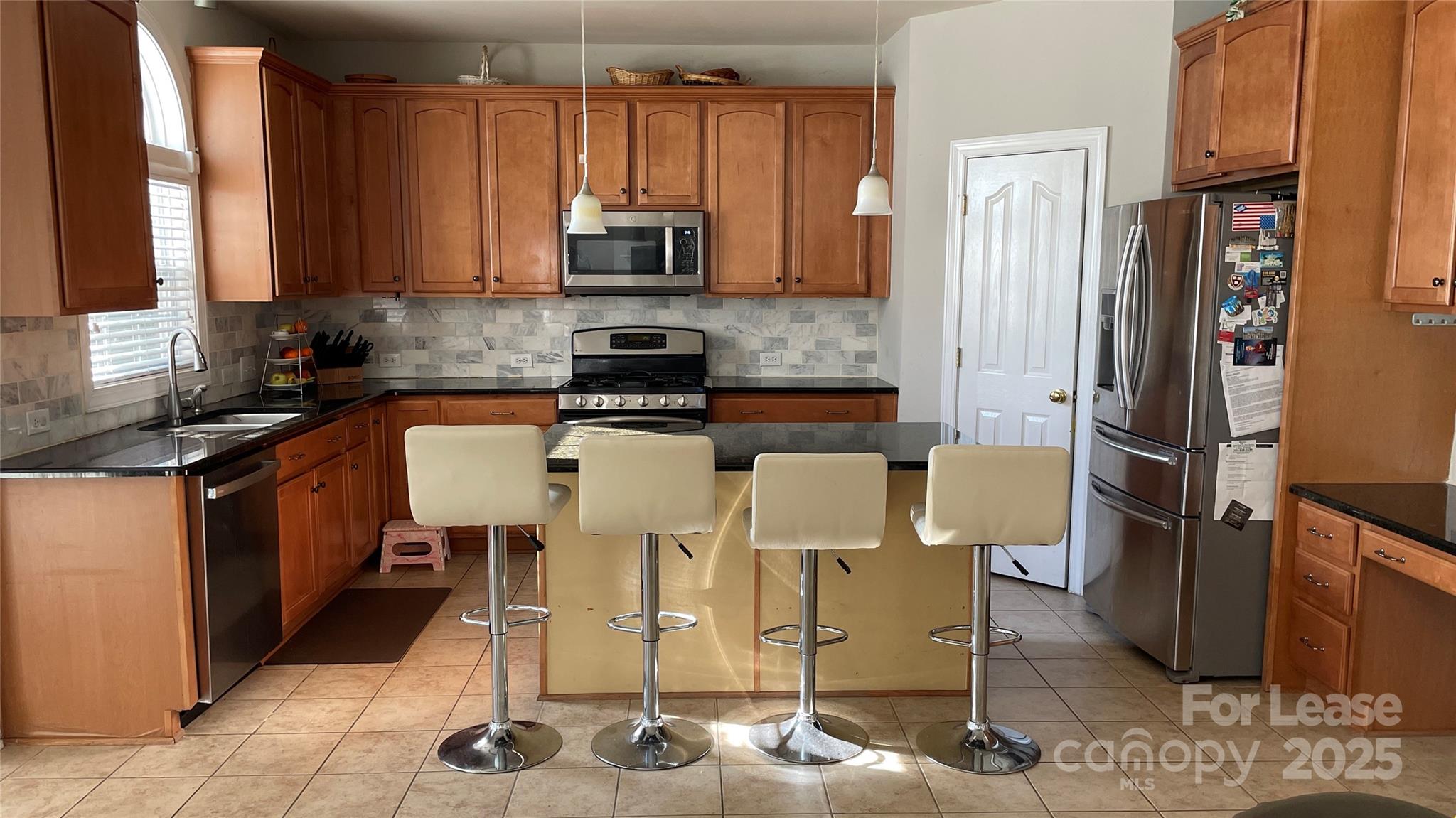 14701 Provence Lane Charlotte, NC 28277 - Photo 7 of 10 a kitchen with stainless steel appliances kitchen island granite countertop a refrigerator and a stove top oven