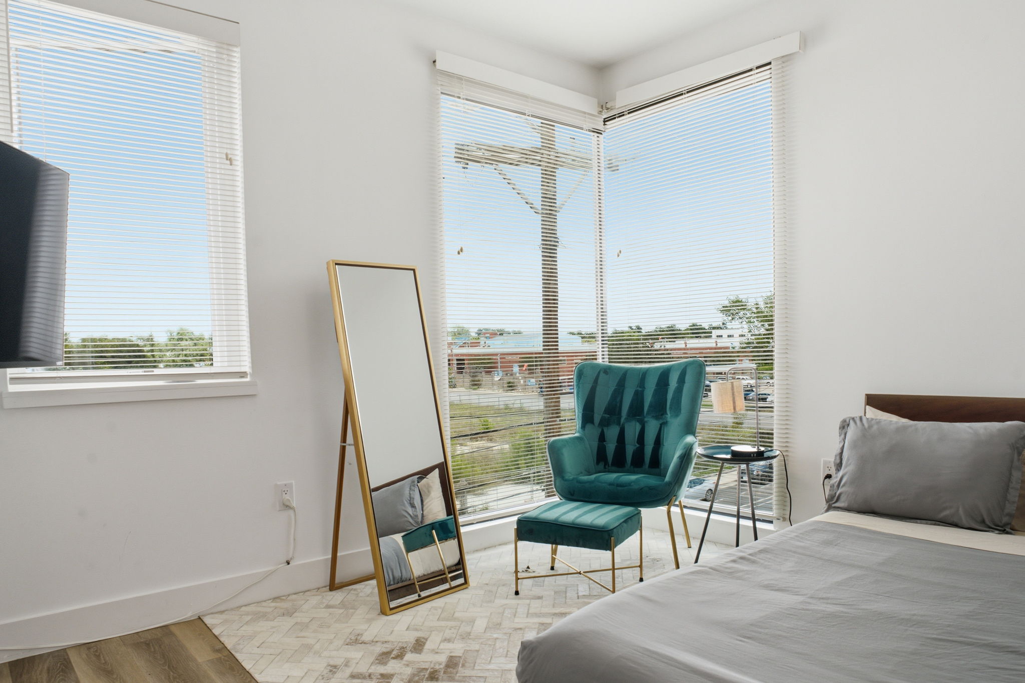 2709 East 5th Street, Unit 1306 Austin, TX 78702 - Photo 17 of 28 Natural light streams into this bedroom through multiple large windows with horizontal blinds.