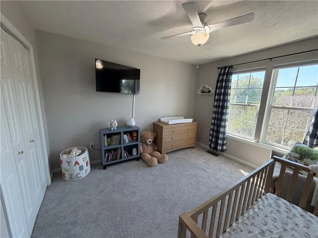 a living room with furniture a flat screen tv and a window