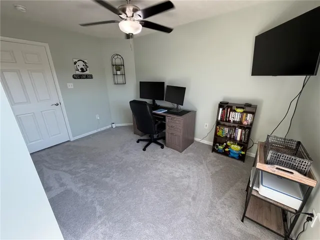 a view of a workspace with furniture and a window