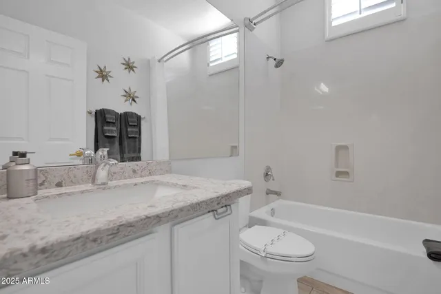a bathroom with a granite countertop sink a toilet and a bathtub