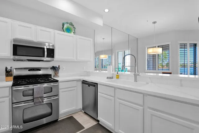 a kitchen with appliances a sink and cabinets