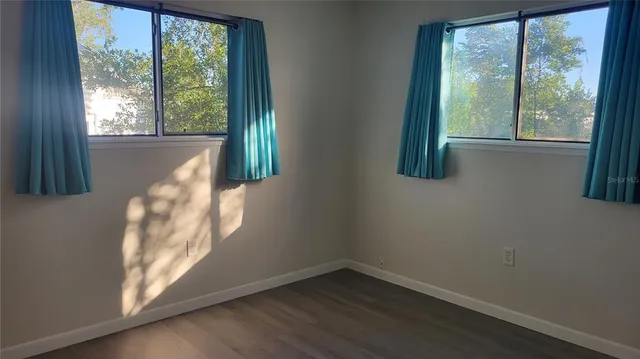 a view of a small space with wooden floor and a window