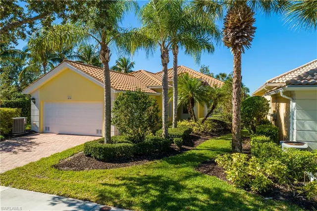 a view of a house with a yard and palm trees