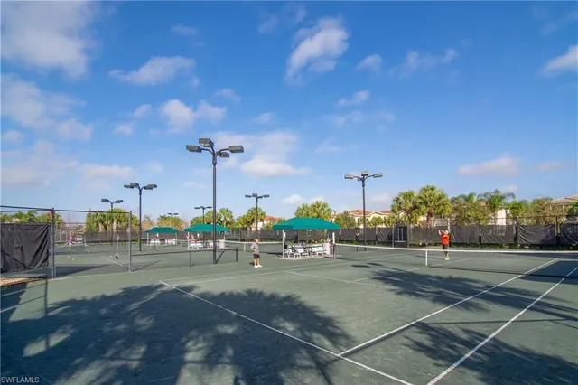 a view of swimming pool with seating area and trees in the background