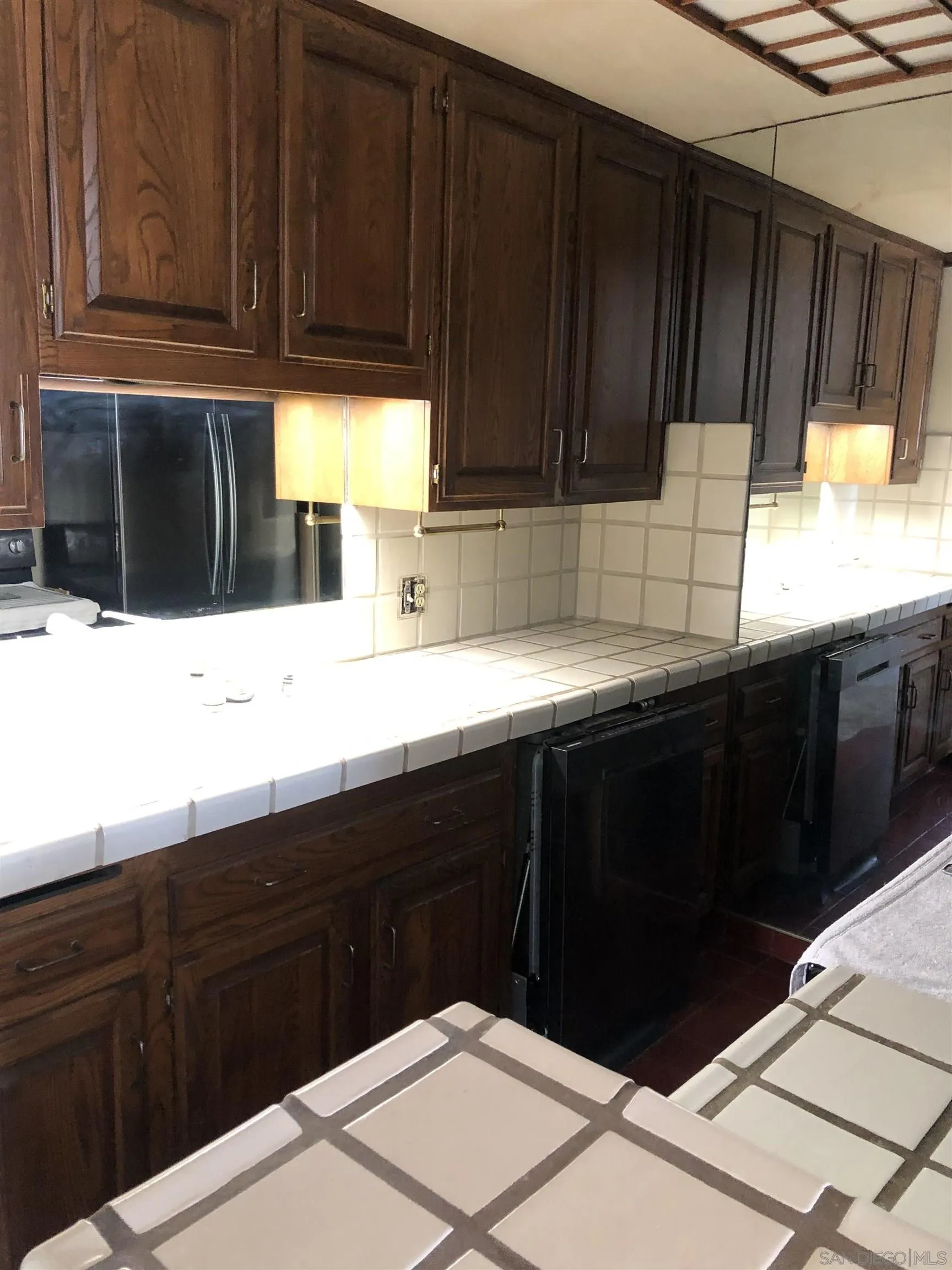 6202 Friars Road, Unit 224 San Diego, CA 92108 - Photo 6 of 13 a kitchen with granite countertop wooden cabinets and a sink