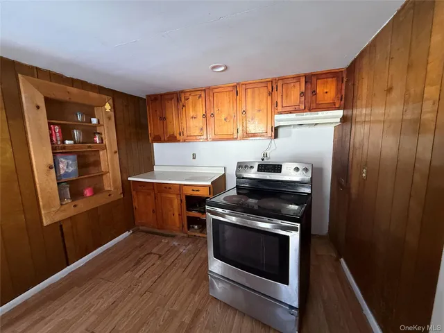 a kitchen with wooden floor and a stove top oven