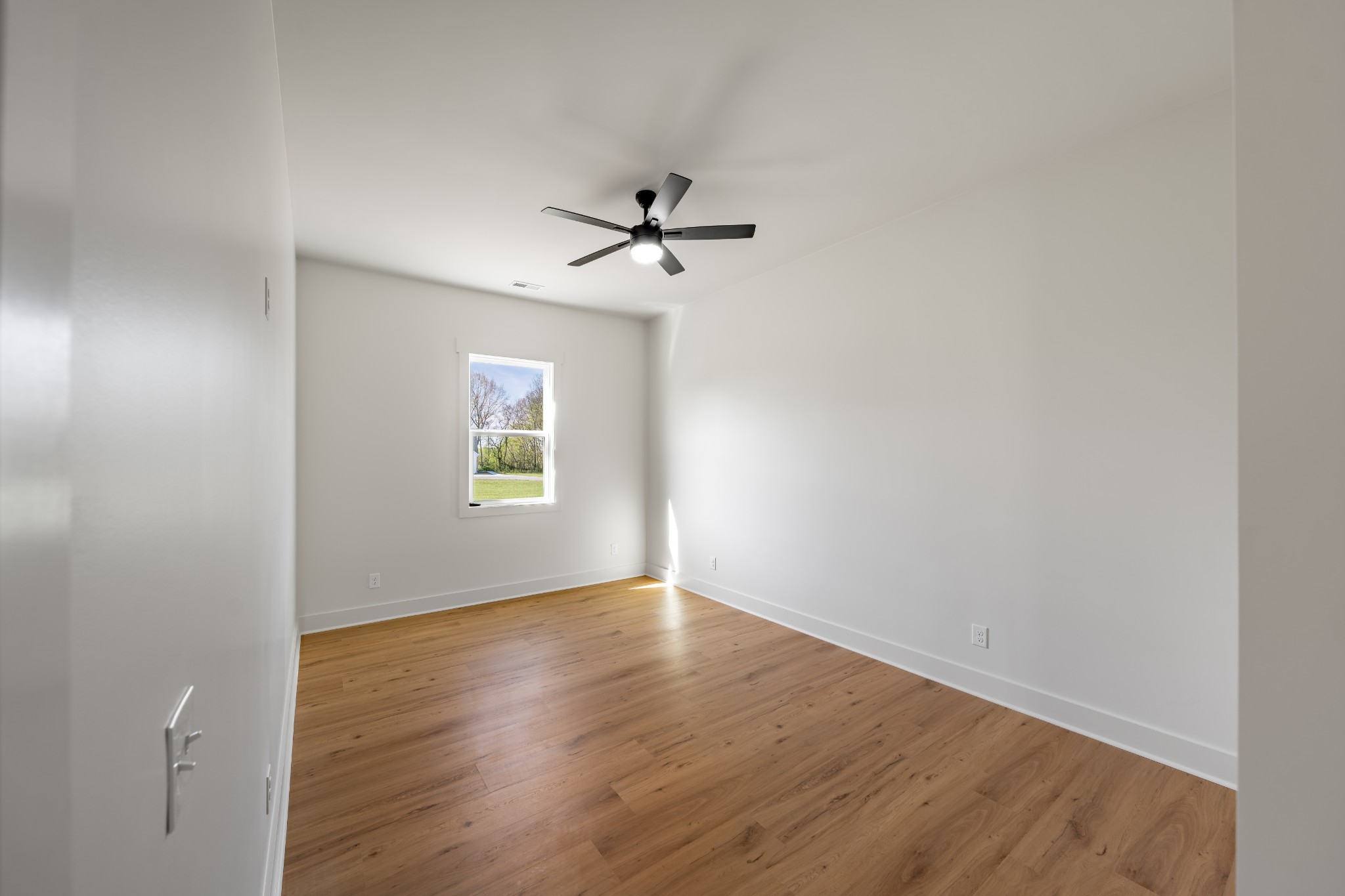 4031 Wells Road Springfield, TN 37172 - Photo 20 of 39 an empty room with wooden floor ceiling fan and windows