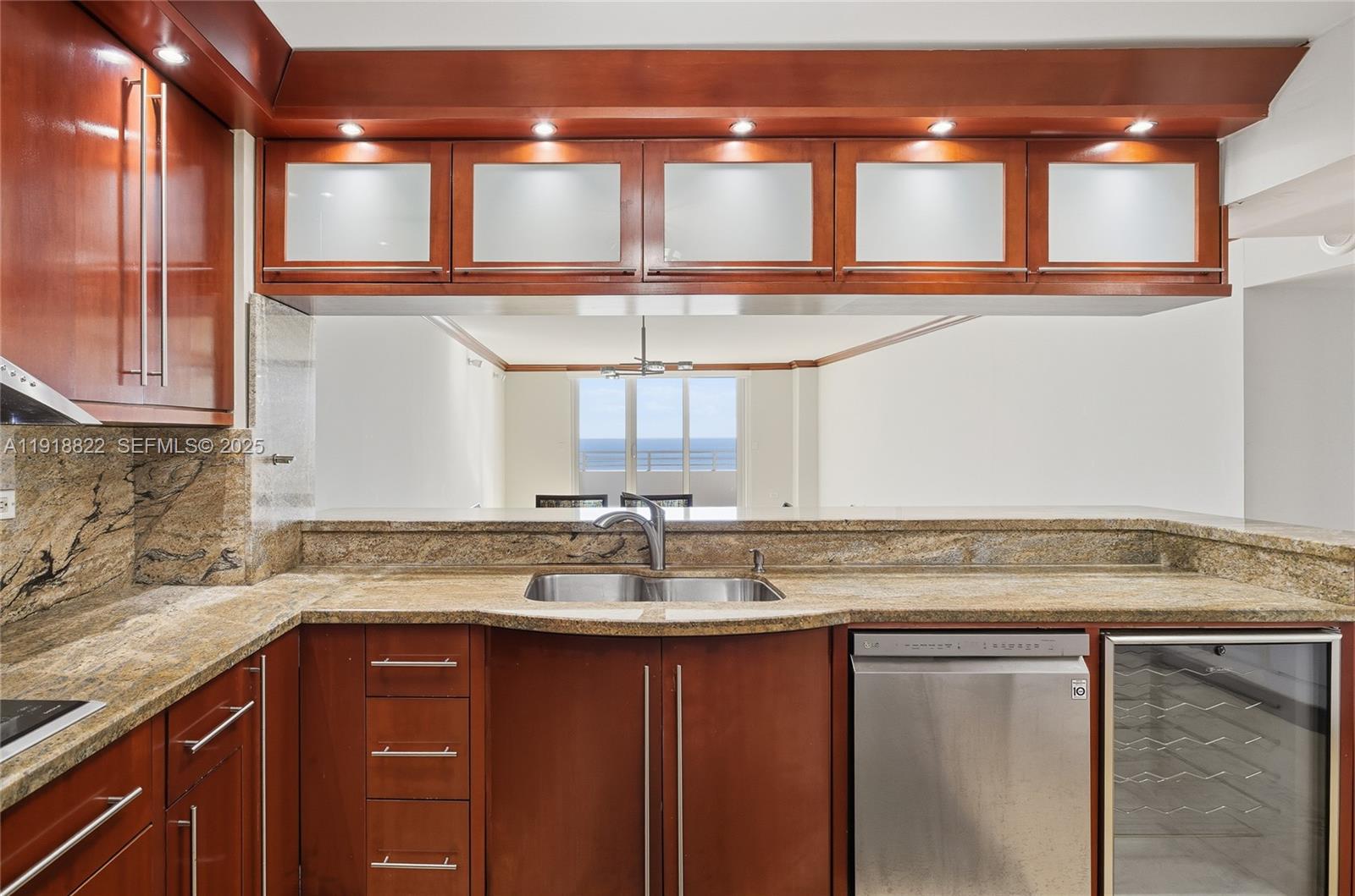 5555 Collins Avenue, Unit 12N Miami Beach, FL 33140 - Photo 18 of 49 a kitchen with a sink a window and cabinets