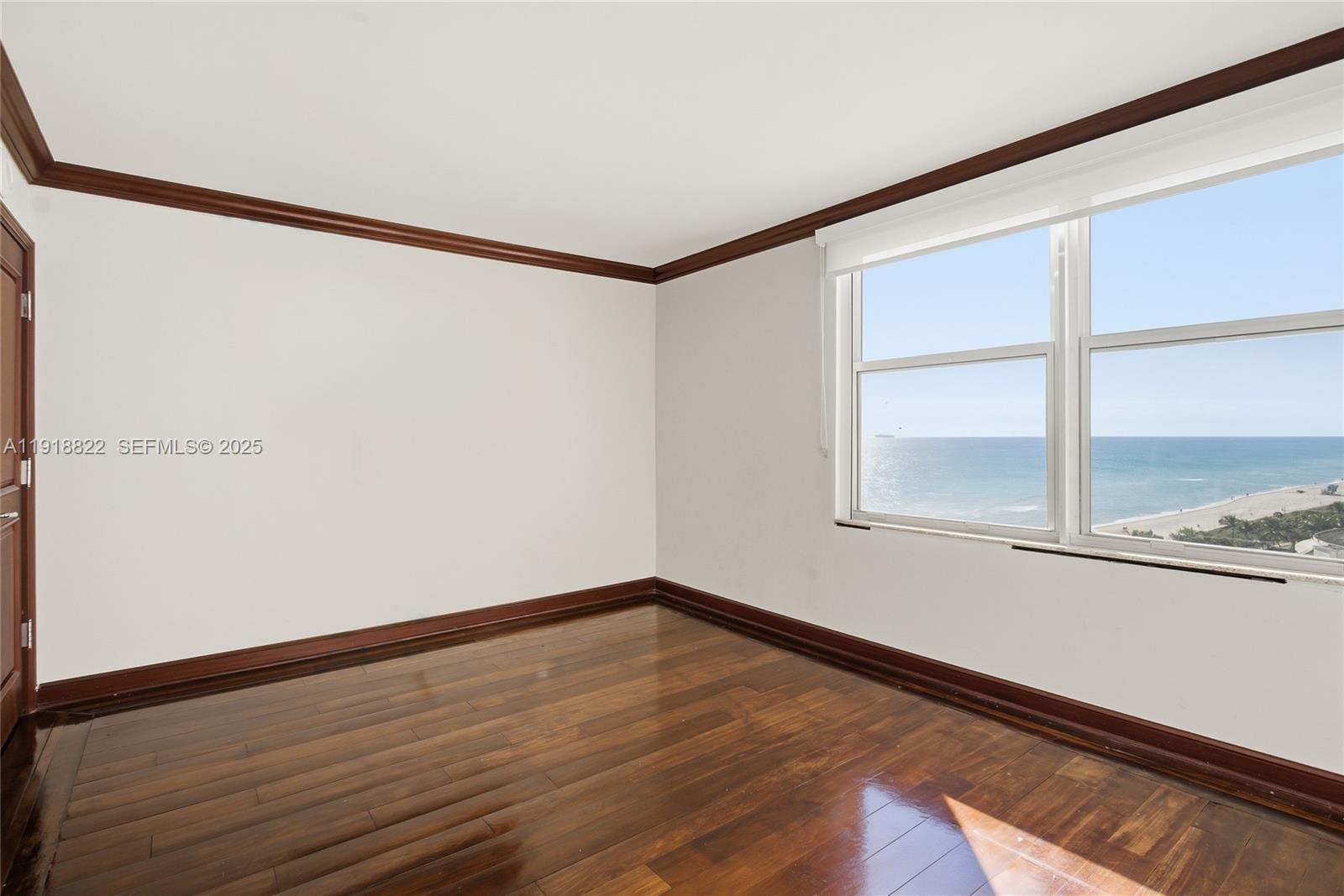 5555 Collins Avenue, Unit 12N Miami Beach, FL 33140 - Photo 24 of 49 a view of an empty room with a window and wooden floor