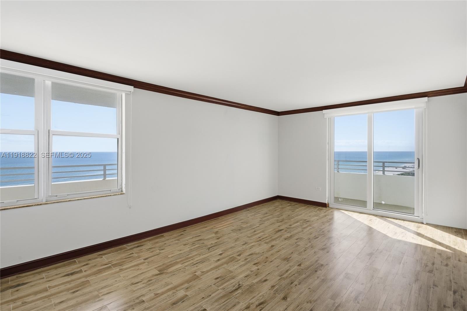 5555 Collins Avenue, Unit 12N Miami Beach, FL 33140 - Photo 29 of 49 a view of an empty room with wooden floor and a window