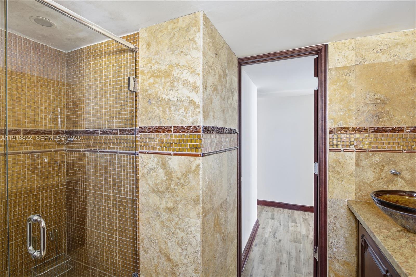 5555 Collins Avenue, Unit 12N Miami Beach, FL 33140 - Photo 35 of 49 a bathroom with a granite countertop sink a mirror and shower