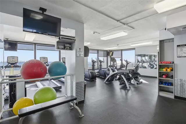 a room with gym equipment and a flat screen tv