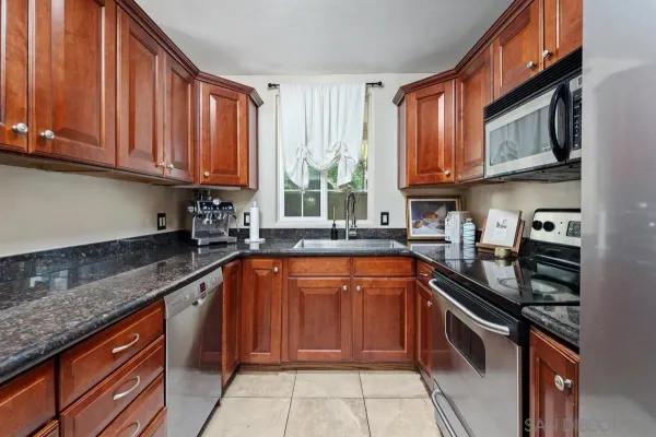 a kitchen with stainless steel appliances granite countertop a stove sink microwave and cabinets