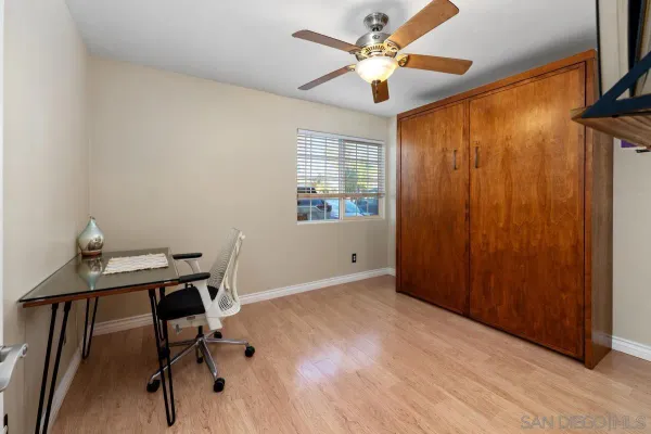 a view of a workspace with furniture and a window