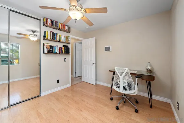 a view of a workspace with furniture and a book shelf