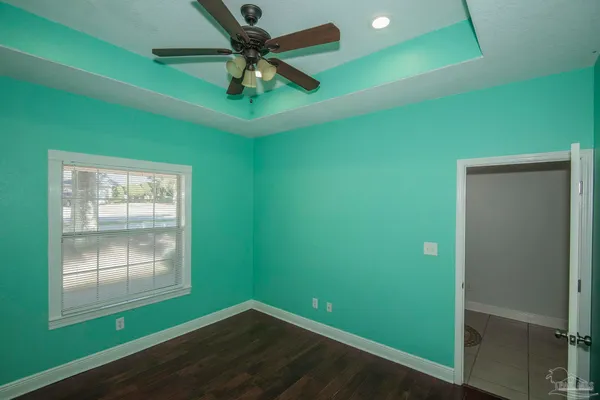 a view of a livingroom with a fireplace a ceiling fan and wooden floor