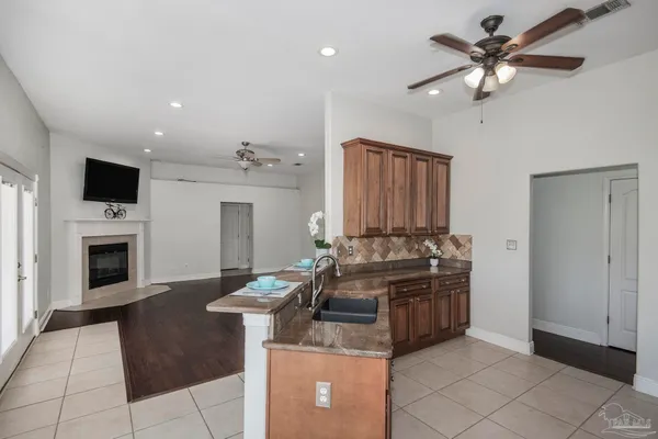 a kitchen with kitchen island granite countertop a stove top oven a sink a counter space and cabinets