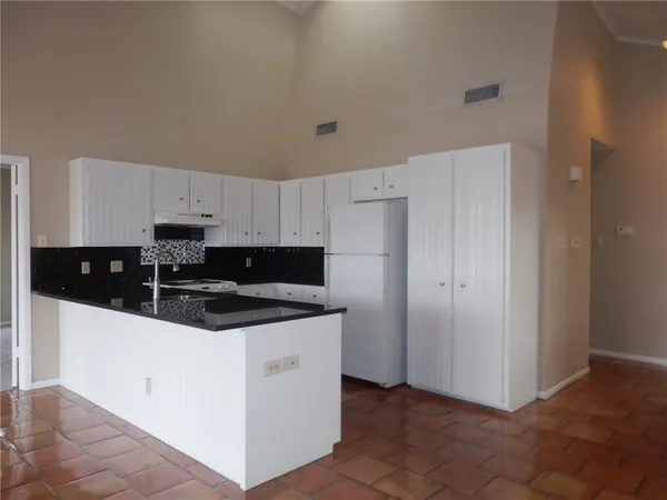 a kitchen with granite countertop white cabinets and stainless steel appliances