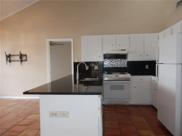 a kitchen with a stove and white cabinets