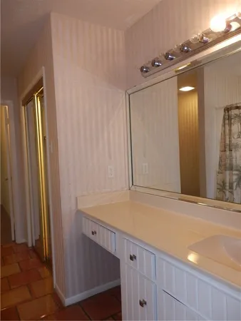 a bathroom with a granite countertop toilet and a shower