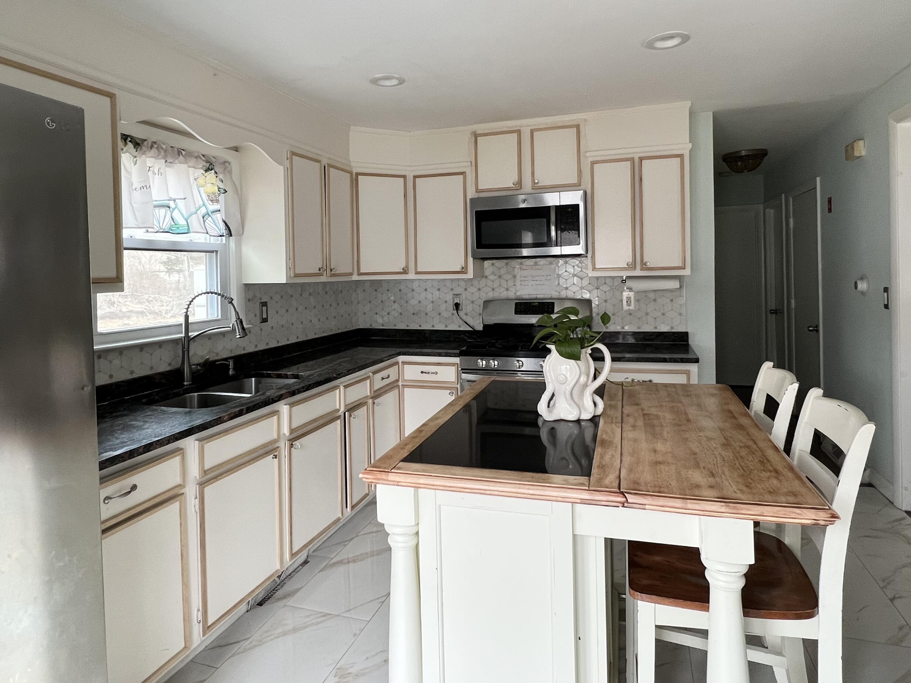 140 Mitchells Way Hyannis, MA 02601 - Photo 12 of 45 a kitchen with stainless steel appliances granite countertop a sink a stove a microwave a refrigerator a counter top space and cabinets
