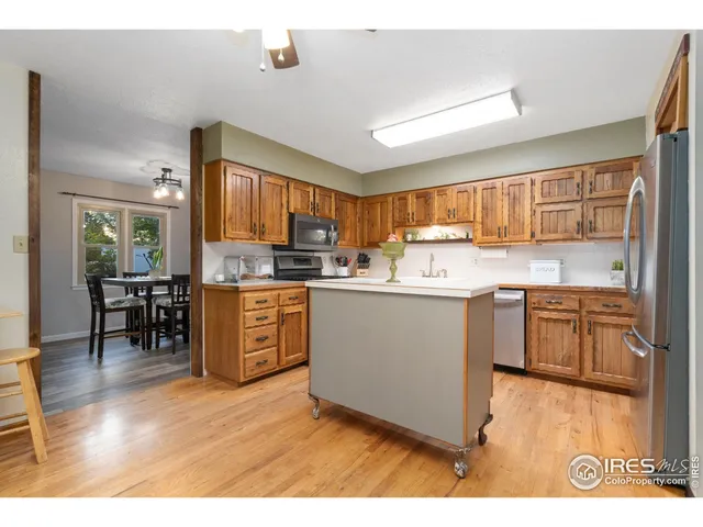 a kitchen with a sink wooden cabinets and stainless steel appliances