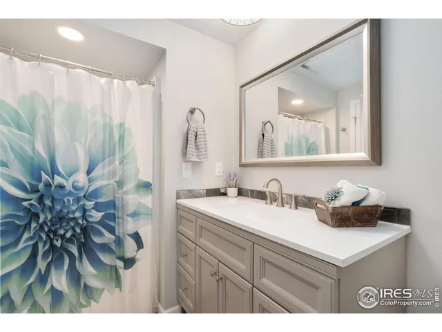 a bathroom with a sink a mirror and a shower curtain