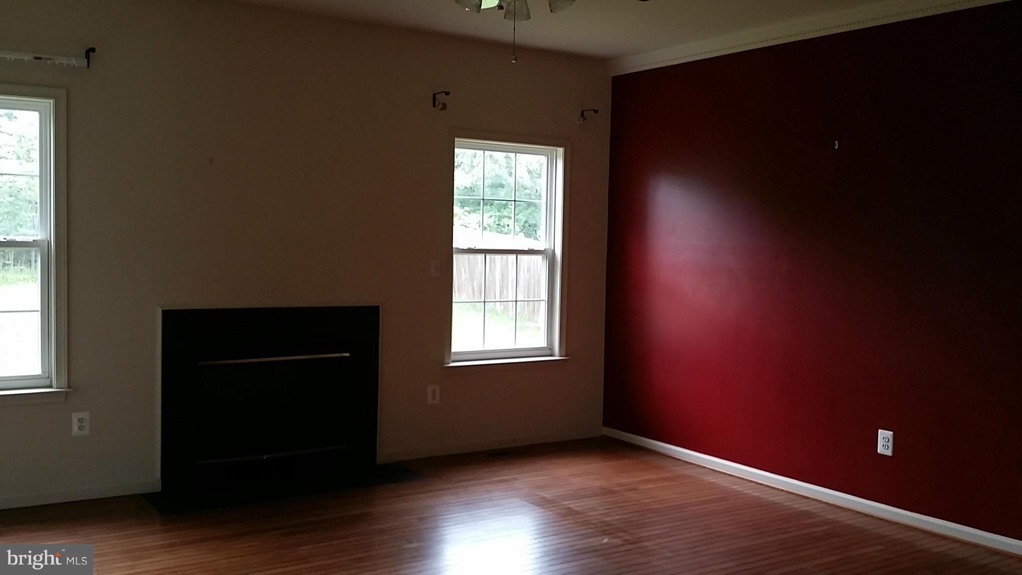 2706 Rona Road Baltimore, MD 21207 - Photo 2 of 10 a view of an empty room with wooden floor and a window
