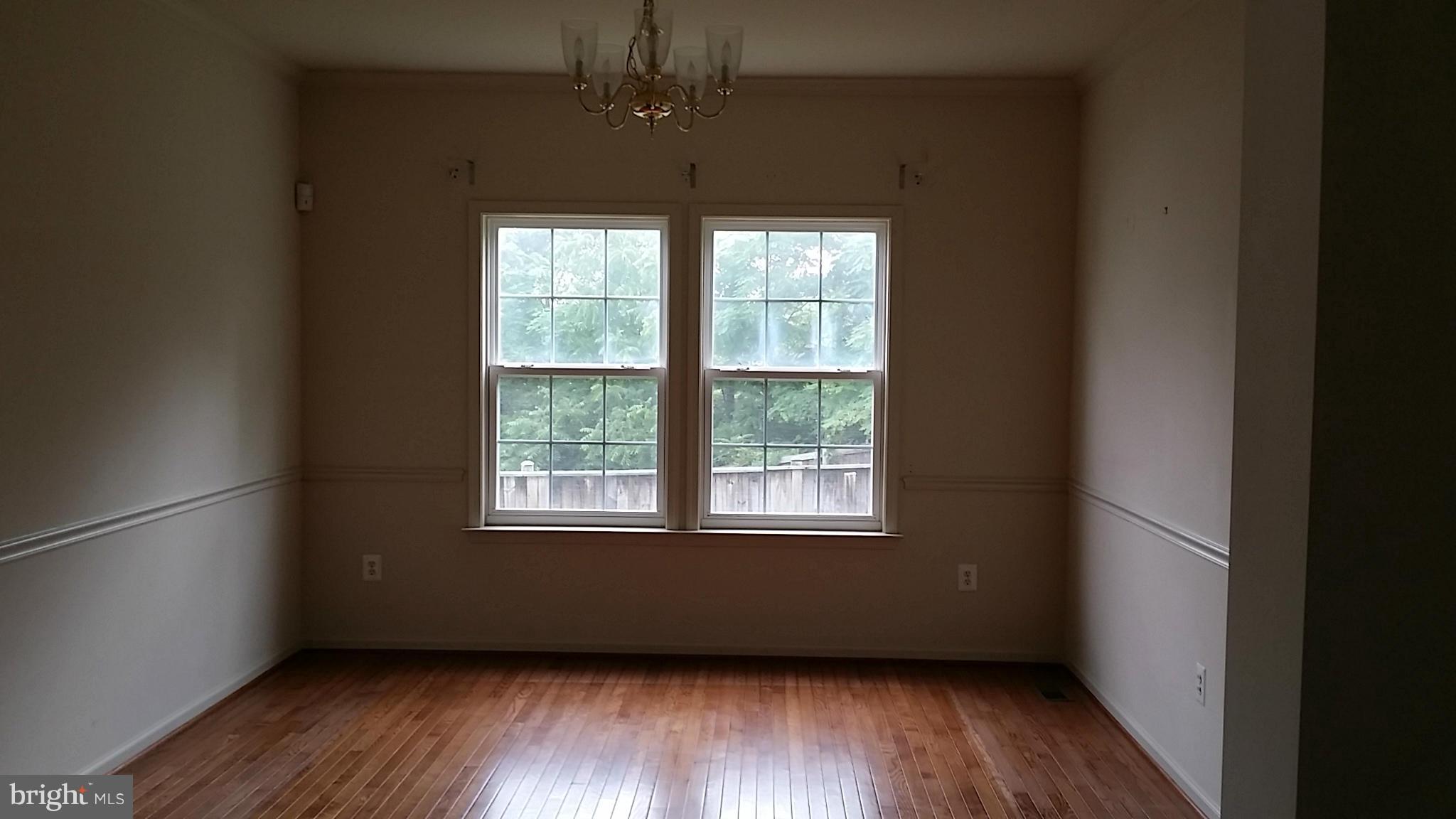 2706 Rona Road Baltimore, MD 21207 - Photo 3 of 10 an empty room with wooden floor and windows