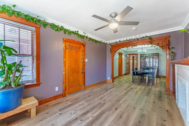 a view of a livingroom with wooden floor and a ceiling fan